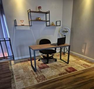 A desk with a chair and a computer on it

Description automatically generated